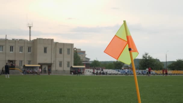 Žlutá a oranžová rohová vlajka vlající ve větru na fotbalovém hřišti. Fotbalový zápas — Stock video