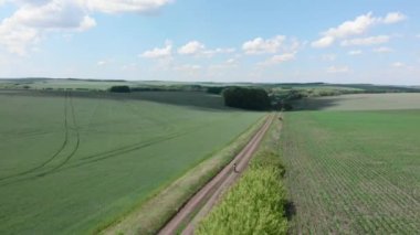 Çakıl bisikleti. Çakıl yolu üzerinde bisiklet süren bir bisikletçi. Kadın bisiklete biniyor