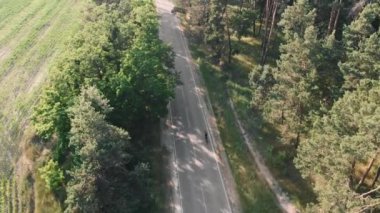 Yolda destansı bisiklet süren bir motosikletli. Yoğun antrenman ve egzersiz. Bisiklet triatlonu motivasyonu