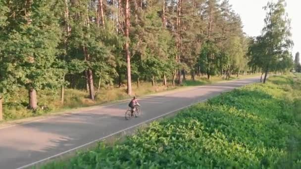 Radsport-Motivation. Triathlon training. Frau radelte bei Sonnenuntergang auf Rennrad — Stockvideo