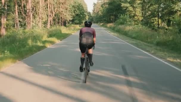 Kvinnlig cyklist cykling på landsbygden väg. Kvinnliga idrottare utbildning på cykel — Stockvideo