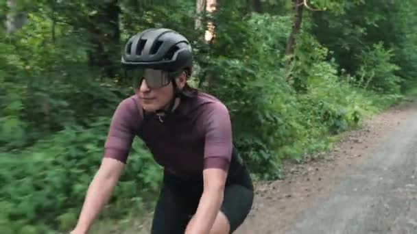 Fietsen bij zonsondergang. Vrouw fietsend in het bos. Vrouwelijke fietser op de fiets door bomen — Stockvideo