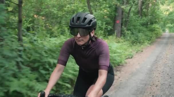 Retrato de mujer en bicicleta. Bicicleta ciclista en carretera de grava en el bosque — Vídeos de Stock