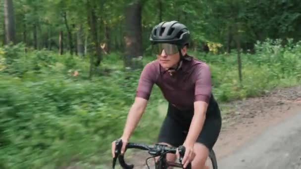 Kadın bisikleti. Bisikletçi çakıllı yolda bisiklet sürüyor. Ormanda bisiklet süren bir kadın. — Stok video