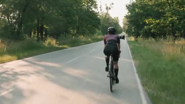 Kobieta na rowerze. Trening rowerzystów na rowerze o zachodzie słońca. Trening rowerowy o wschodzie słońca — Wideo stockowe