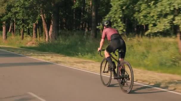 Woman intensively pushing pedals on bicycle. Cyclist twists pedals on bike, sprinting out of saddle — Stock Video