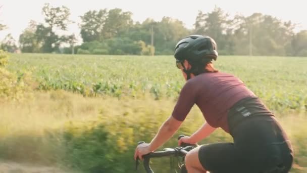 女の子のペダリング自転車。日の出に自転車に乗るサイクリスト。日没時に自転車で自転車に乗る女性 — ストック動画