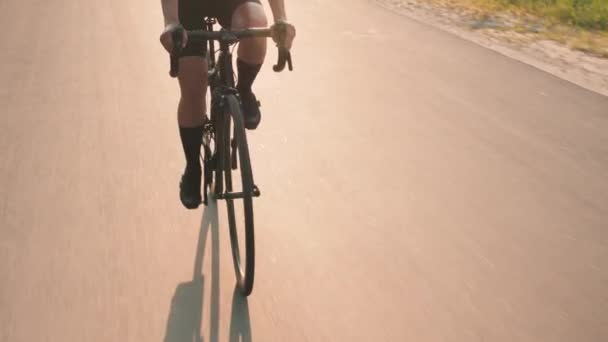 Профессиональный триатлонист на велосипеде на закате. Женщина тренируется на велосипеде на рассвете. Вращение велосипедного колеса — стоковое видео