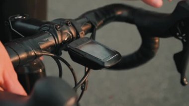 Bisikletçi GPS aygıtı üzerinde başlatma düğmesine basıyor, kayıt yapıyor ve bisiklet sürmeye başlıyor