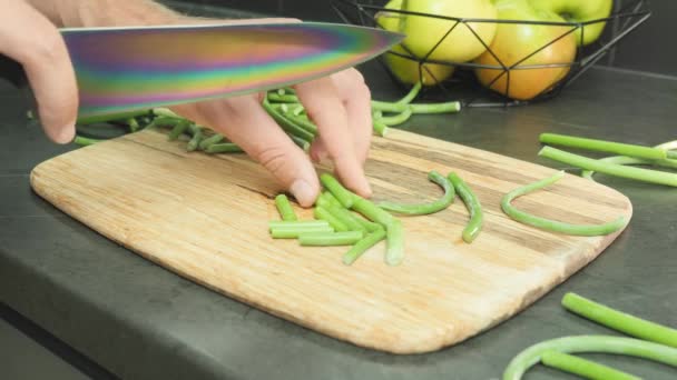 Vrouw snijdt groene bonen op snijplank. Groene bonen snoeien op houten snijplank — Stockvideo