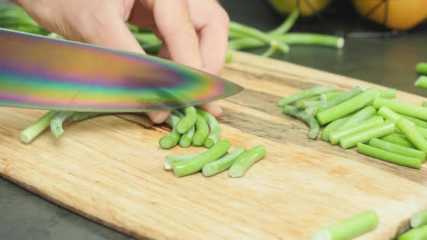 Ajo silvestre cortado sobre tabla de cortar de madera. Rebanando brotes verdes de ajo — Vídeos de Stock