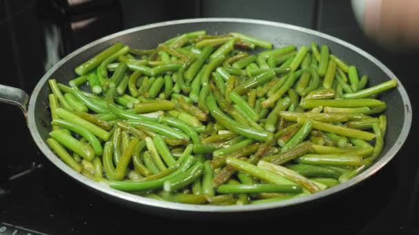 Fritar ovos saborosos com feijão verde na panela quente. Homem quebrando ovo em frigideira — Vídeo de Stock