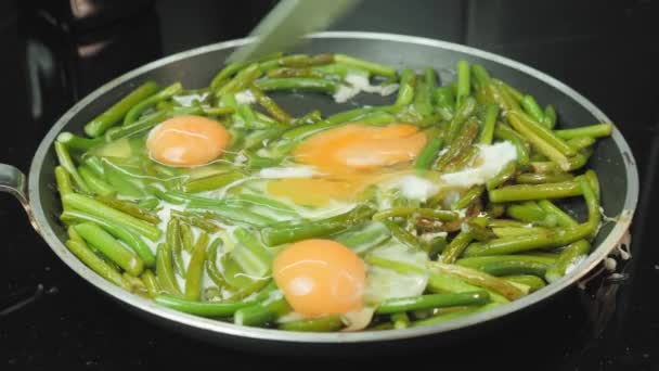 Ovos e feijões verdes na frigideira. Fritar ovos mexidos em frigideira — Vídeo de Stock