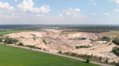 Flight over giant clay iron ore quarry. Huge open mining with mounds of minerals