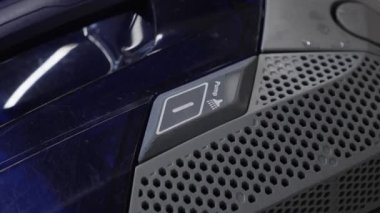 Elektrik süpürgesinde su pompası düğmesine basan parmak. Yerleri elektrikli süpürgeyle yıkıyorum.