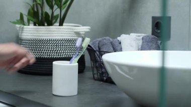 Sabahleyin plastik deney şişesinden diş fırçası alan adam. Ağız temizliği.