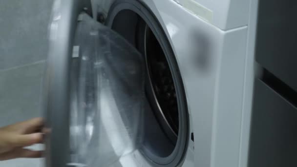 Femme faisant la lessive à la maison, sortir des vêtements blancs de la machine à laver — Video