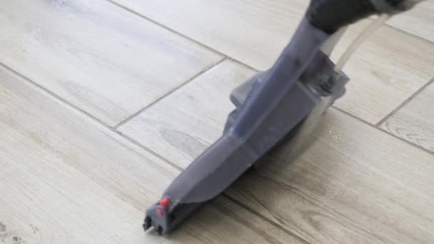Odkurzacz, zbliżenie szarej plastikowej dyszy ze szczotkami przejeżdżającymi przez betonową podłogę — Wideo stockowe
