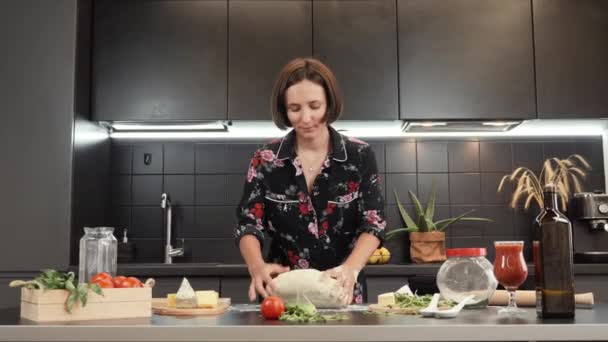 Mujer amasando masa para pan casero o pizza. Cocina femenina joven en la cocina casera — Vídeos de Stock