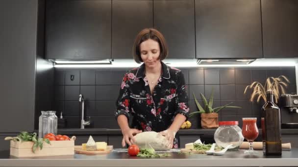 Mujer amasando masa para pan casero o pizza. Cocina femenina joven en la cocina casera — Vídeo de stock