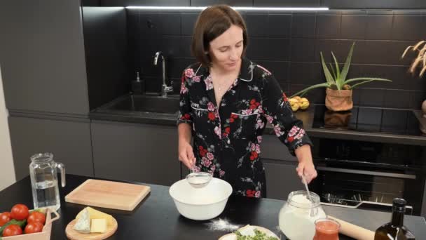 Mulher peneira farinha através da peneira na cozinha da casa. Feminino usando peneira na cozinha — Vídeo de Stock