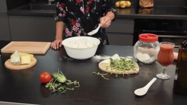 Kadın evde geleneksel pizza için hamur hazırlıyor. Aile için yemek pişiren kadın.