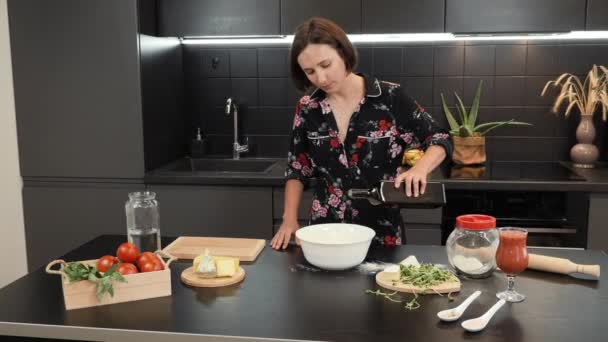 Kvinnan lagar mat i köket. Kvinna förbereder hälsosam middag för familjen — Stockvideo
