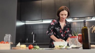 Kadın pizza için hamur hazırlıyor. Kadın evde geleneksel İtalyan pizzası yapıyor.