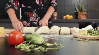Ekmek ya da pizza için hamur yapmak. Tatlı fırın için hamur kesen bir kadın