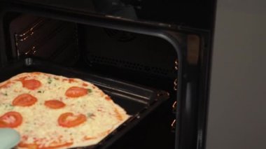 Pizzayı fırına atan kadın. Elektrikli konveksiyon fırınında İtalyan pizzası pişirmek
