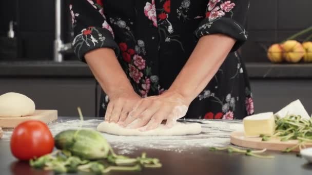 Preparación de la masa para la pizza en la mesa. Mujer amasando masa para pizza base en la cocina — Vídeos de Stock