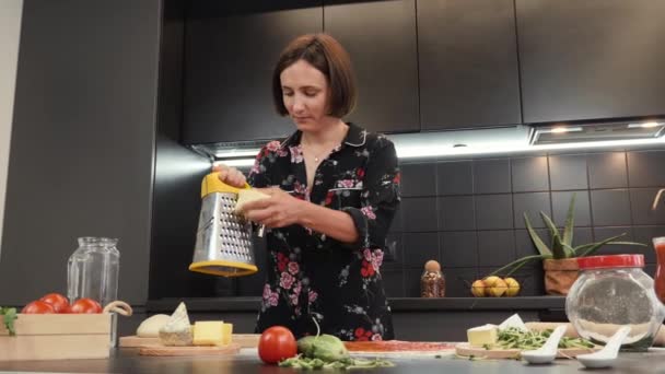 Mulher ralando queijo duro. Cozinha italiana. Feminino preparando pizza caseira tradicional — Vídeo de Stock