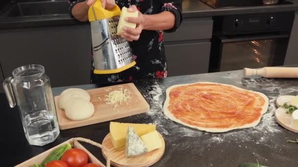 Mãos ralam queijo no ralador de metal. Mulher fazendo pizza de queijo em casa — Vídeo de Stock