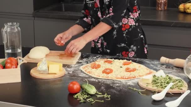 Gotowanie pizzy domowej roboty w nowoczesnej kuchni domowej. Kobieta robi tradycyjną włoską pizzę — Wideo stockowe
