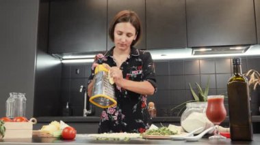 Pizza için Mozzarella peyniri rendeliyorum. Kadınlar peynir ve metal rendesi sandıklar.