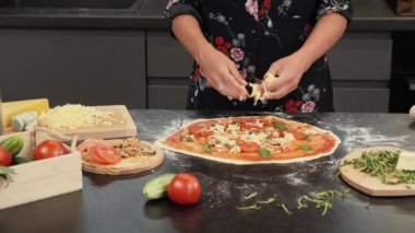 Profesyonel pizza fırıncısı pizzaya peynir ekler, geleneksel İtalyan mutfağı pişirir.