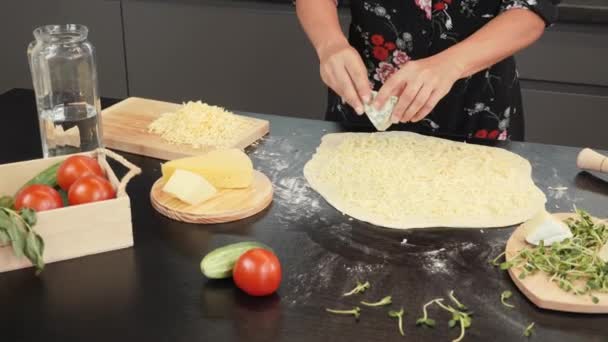 Processus de fabrication de pizza au fromage maison. Mains mettant du fromage bleu sur la base de pizza — Video