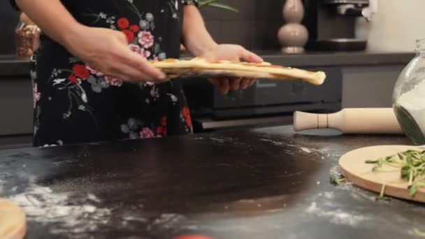Запечена смачна піца на дерев'яному столі. Жінка кладе приготовану піцу на стіл на кухню — стокове відео