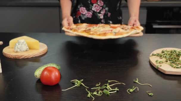 Pizza cozida saborosa. A mulher põe pizza cozida na mesa. Processo de fazer pizza — Vídeo de Stock