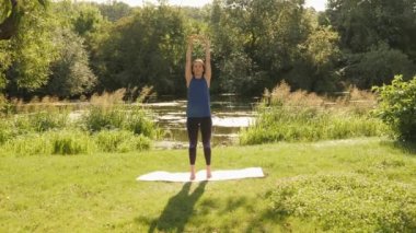 Sabahları parkta esnemek. Yoga egzersizleri. Dışarıda yoga yapan bir kadın.