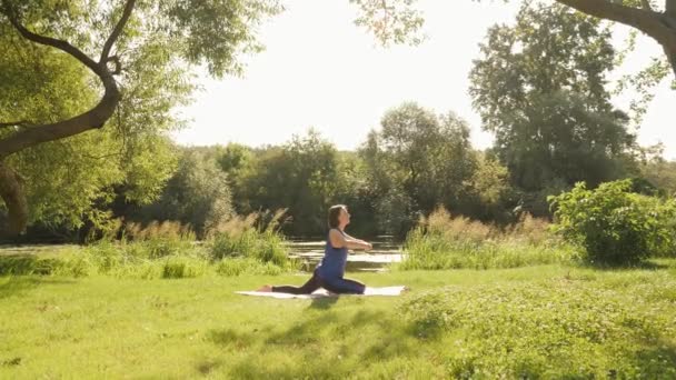 Yoga matutino en el parque. Concepto de meditación. Mujer meditando en el parque de verano al amanecer — Vídeo de stock