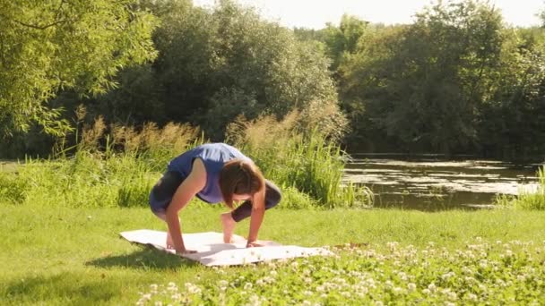 El yoga falla. Mujer tratando de hacer grúa o cuervo postura de yoga, cayendo y riendo — Vídeo de stock