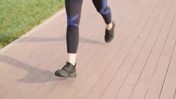 Corridore donna che corre all'aperto, vicino alle gambe. Donna che fa jogging nel parco cittadino — Video Stock