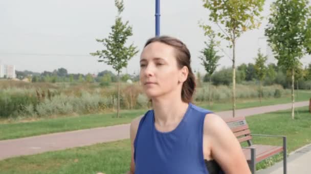 Femme athlétique courant le matin. Jogging féminin dans le parc le long de la rivière — Video