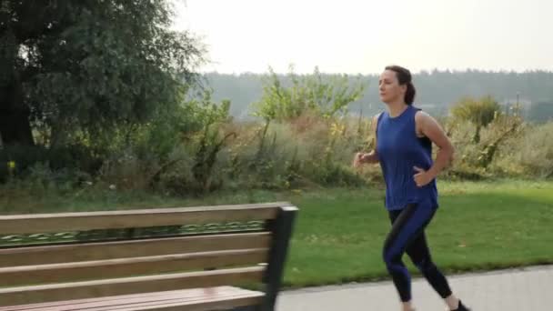 Actieve vrouw die buiten rent. Bepaald vrouwelijk bereiken van haar sportdoelen — Stockvideo