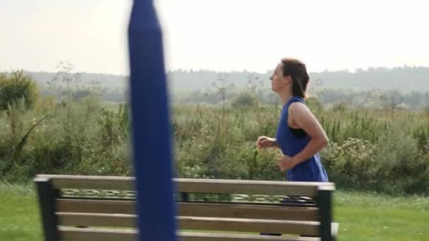 Mujer atleta corriendo en el parque, trotando ejercicio, disfrutando de un estilo de vida saludable — Vídeos de Stock