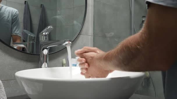 Mencuci tangan dengan sabun dan air panas. Pria membersihkan tangan di kamar mandi tenggelam — Stok Video