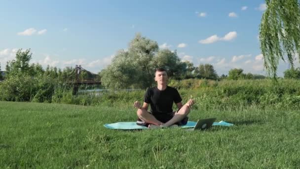 Menneskets meditation. Mand laver yoga øvelser i parken om morgenen. Yoga zen og velvære – Stock-video