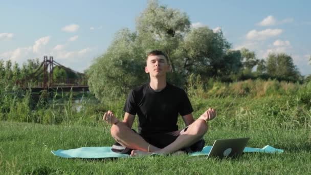 Sabahları yoga. Adam, lotus pozisyonunda yoga ve meditasyon yapıyor. — Stok video