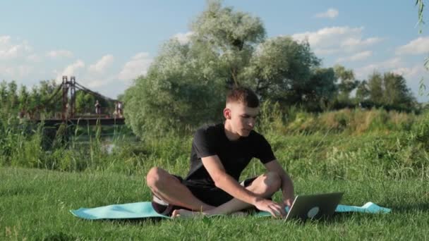 Hombre enfocado practicando yoga al aire libre. Hombre entrenando yoga posan en parque. Concepto zen — Vídeo de stock